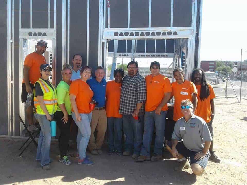 A group of volunteers putting up a house