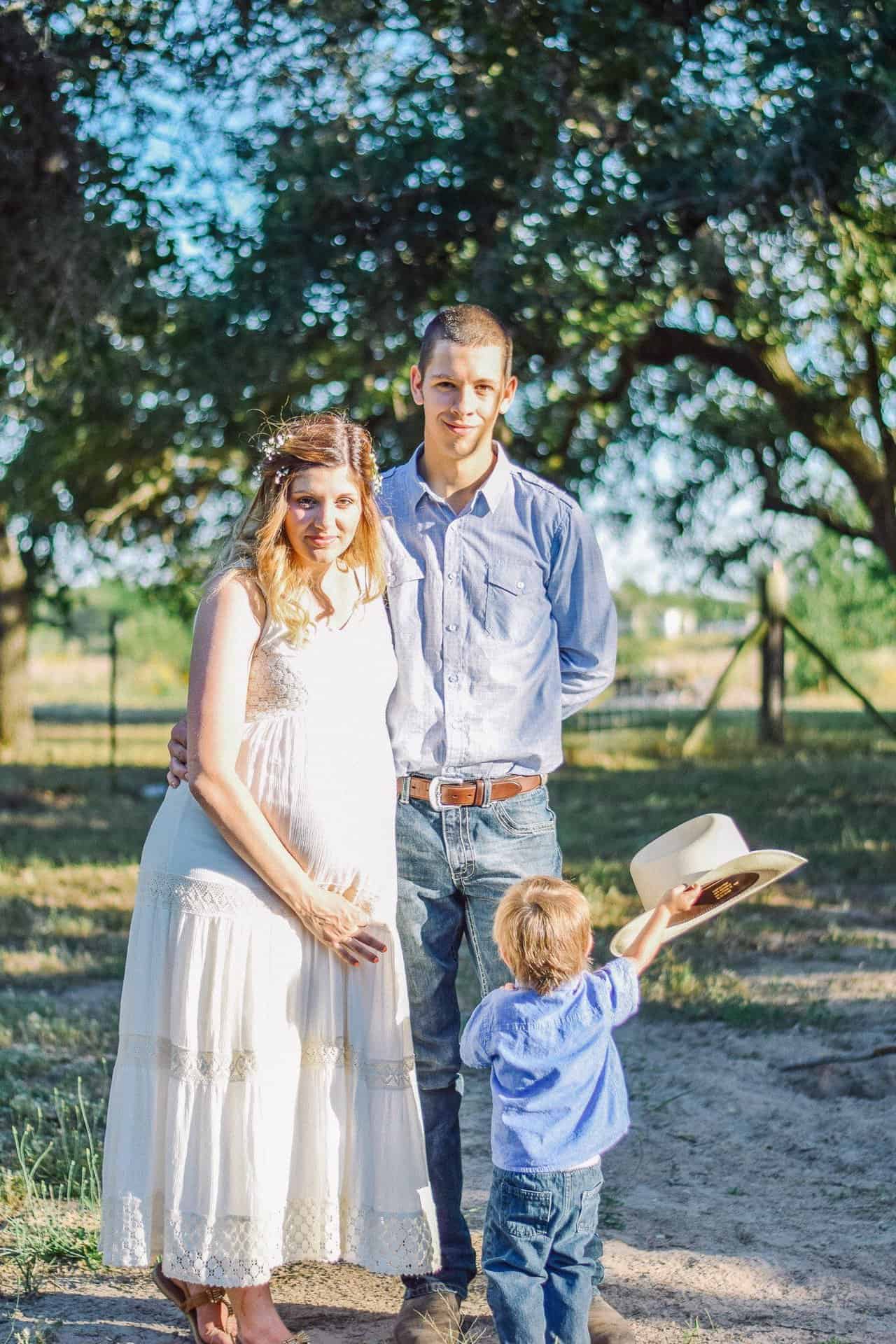 A man, woman, small boy, and a cowboy hat