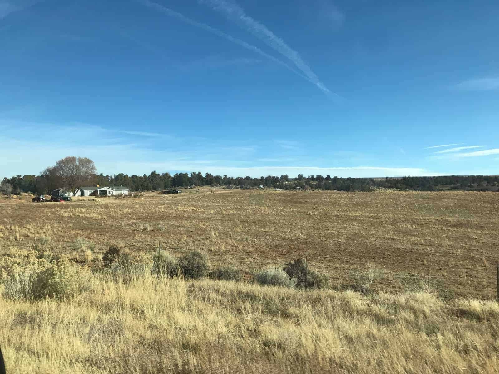 Farm field in late autumn with a home in the background