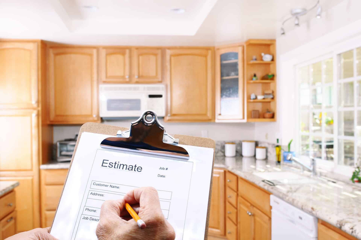 Closeup of a contractors clipboard as he write up an estimate for a kitchen remodel.