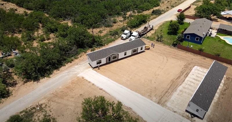 Double wide home being positioned on a caliche base pad