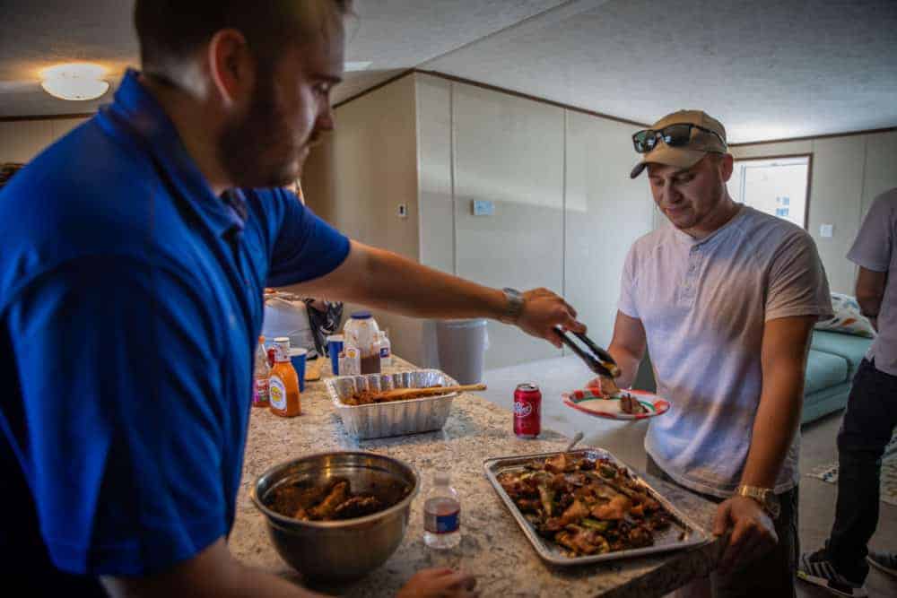 Jason Piña serving food to a man at the Braustin Homes 2019 Dealership grand opening party
