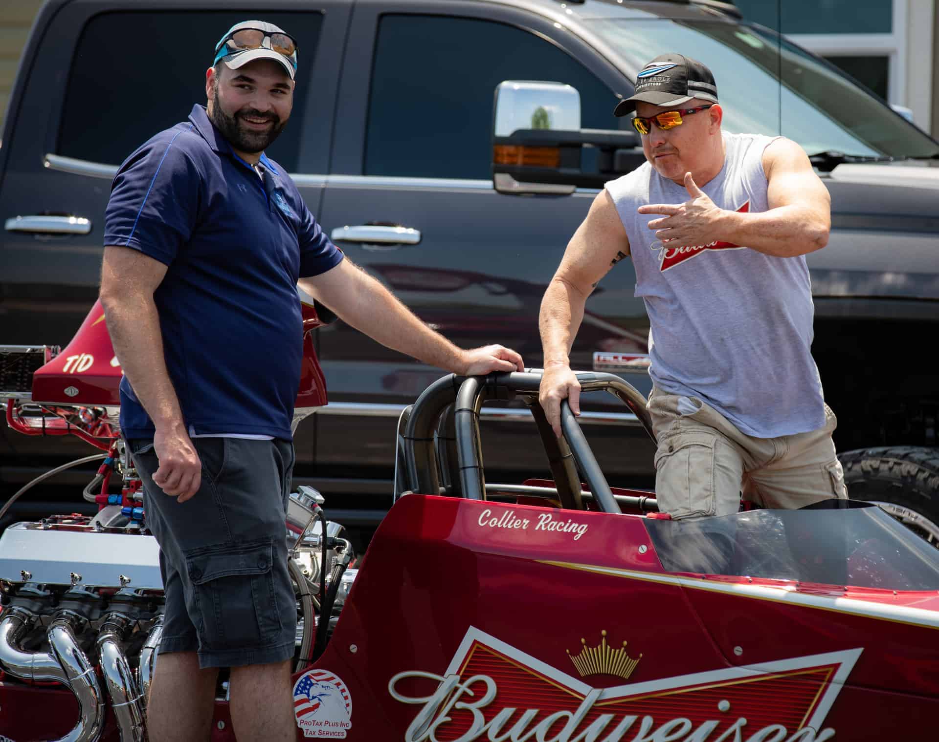 Alberto Piña and another man next to a race car