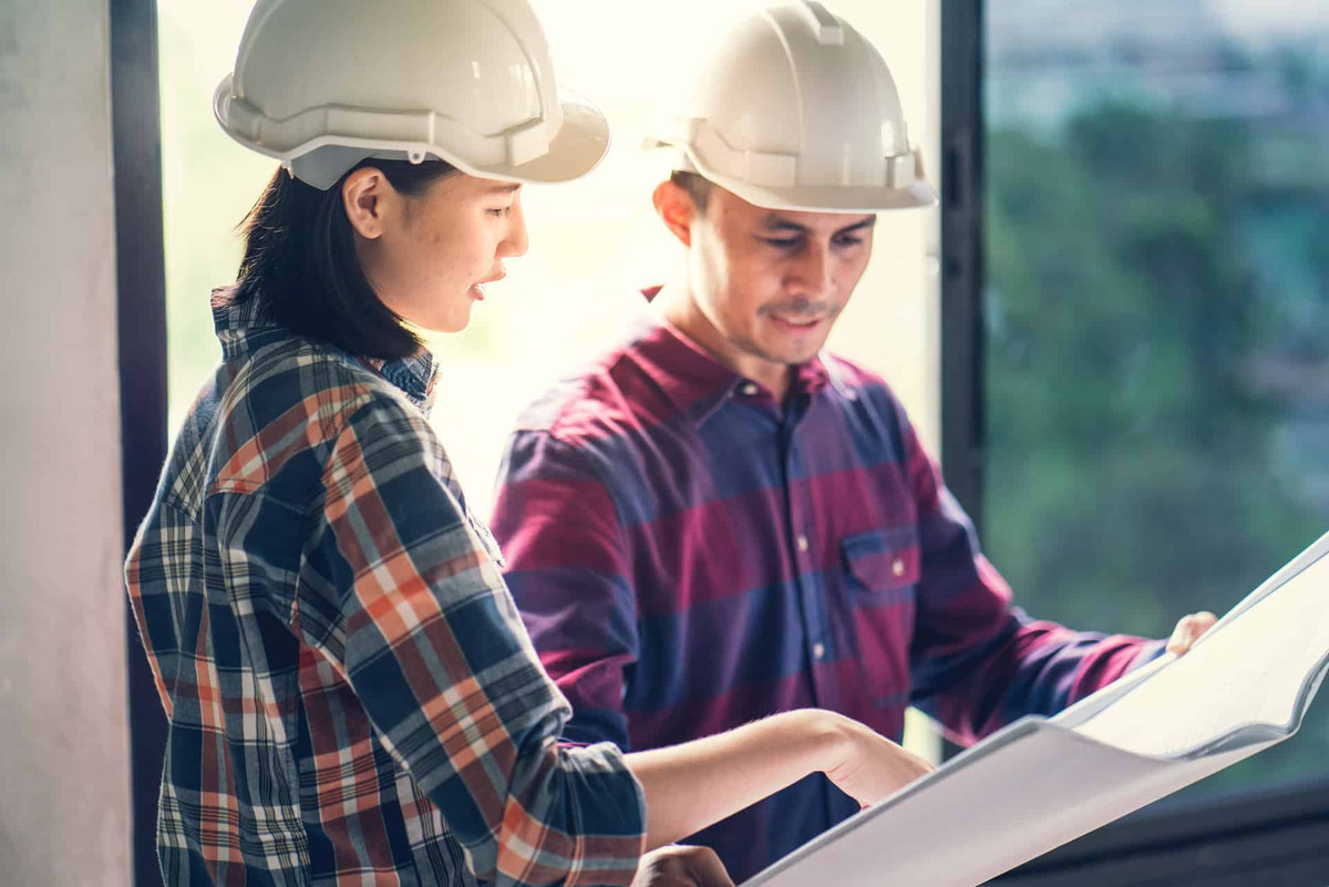 Architect & Engineer working drawing document about project planning and progress of work schedule on the home building construction site