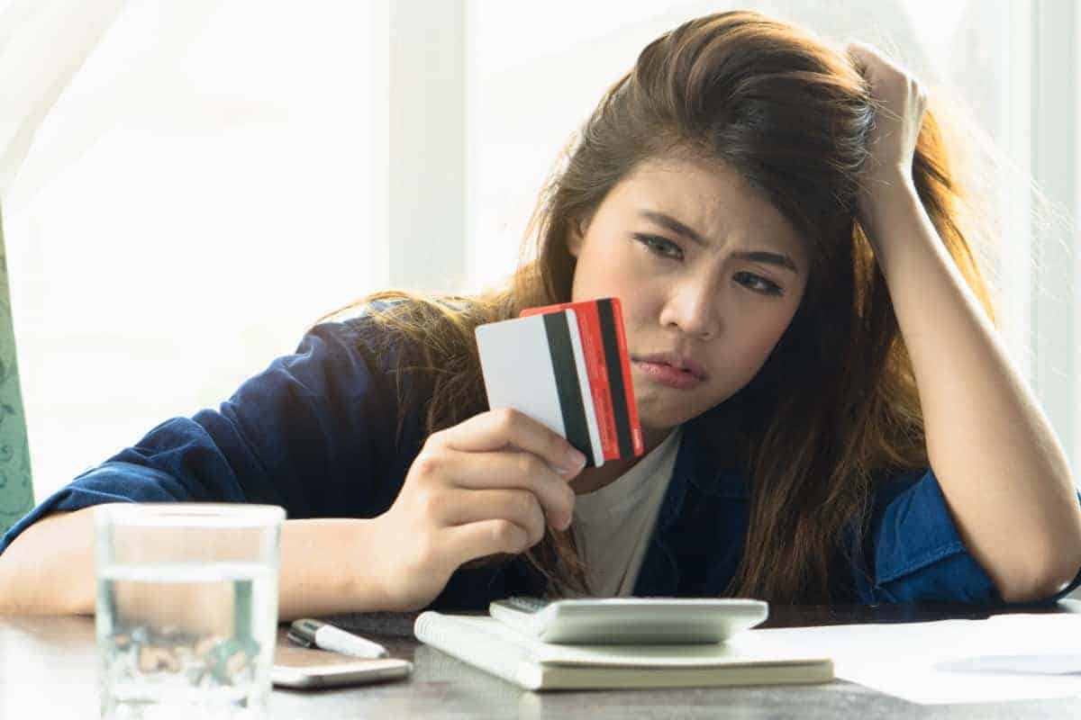 Stressed woman with credit cards in her hands.