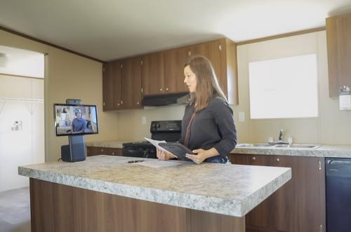 Client talking to a sales rep remotely while touring a mobile home at the Braustin Atascosa dealership